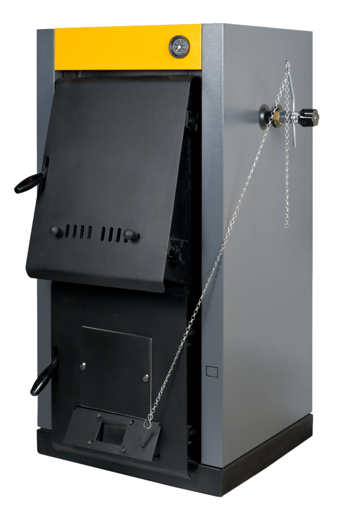 A front view of a gray and yellow industrial heating boiler. The boiler features a large black door with ventilation holes, a control gauge on the top, and a chain for securing the door. The lower section includes a compartment with a foot pedal for operation.